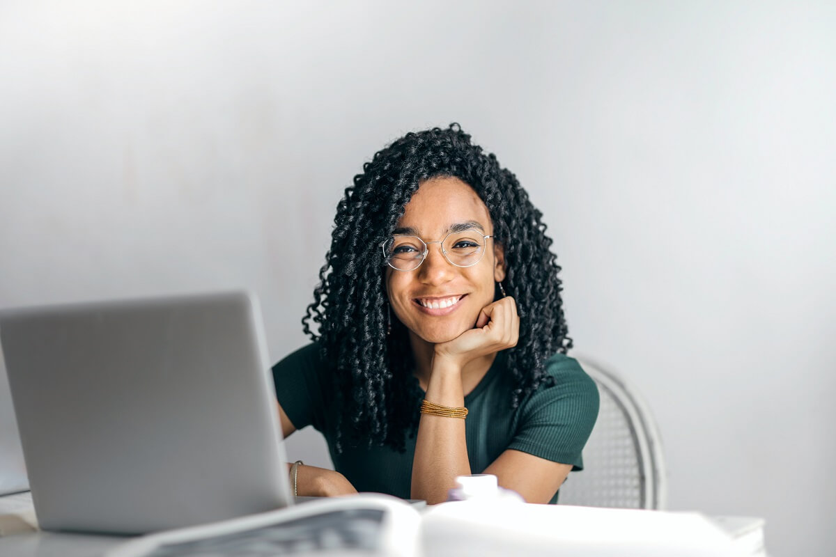 ung leende kvinna vid dator